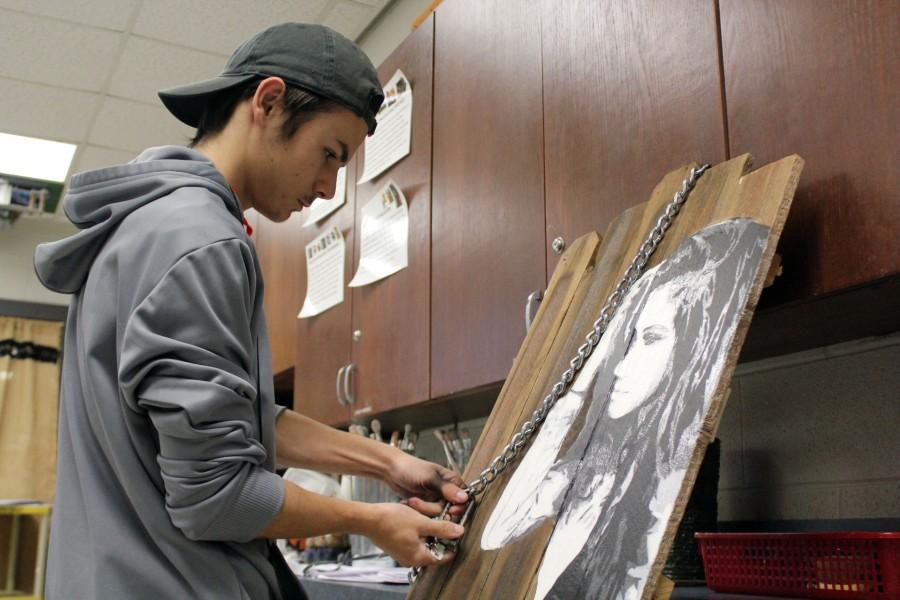 While finishing his art piece, sophomore Robert Russo makes final touches to his work. Its about someone braking down in the emotions, Russo said. 
