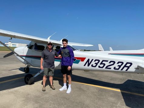 Junior Jordan Duran standing with his flight instructor after flying solo.